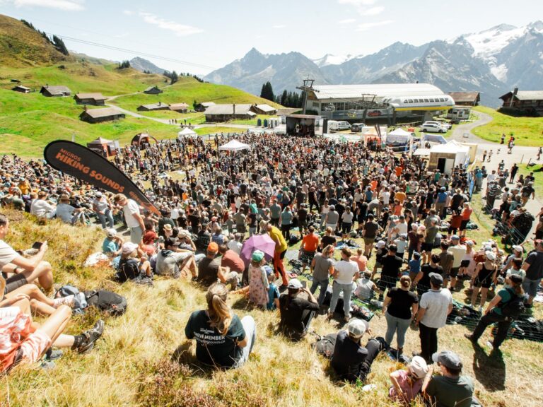 Gruppe von Wanderern versammelt sich in malerischer, alpiner Landschaft.