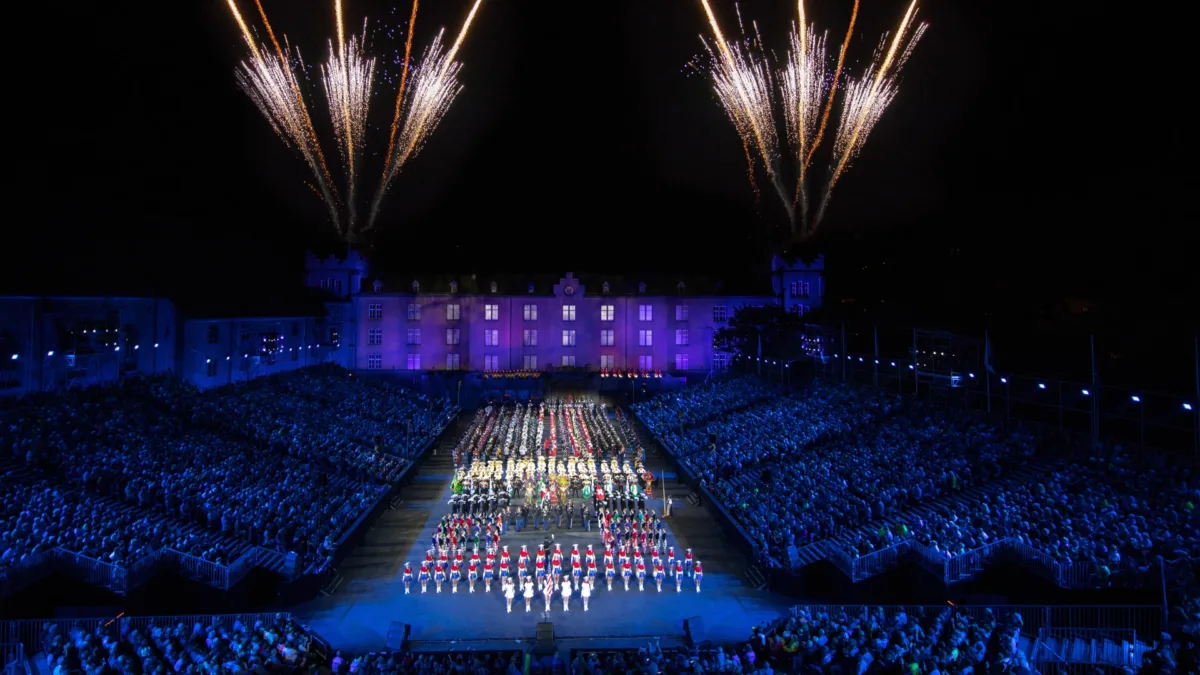 Festlich beleuchtetes Gebäude mit farbigem Feuerwerk im Nachthimmel.