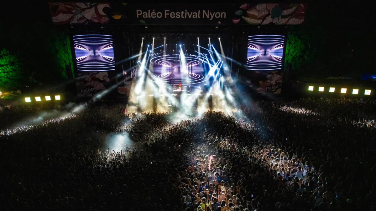 Open-Air-Konzert mit Lichtshow und großer Menschenmenge bei Nacht.