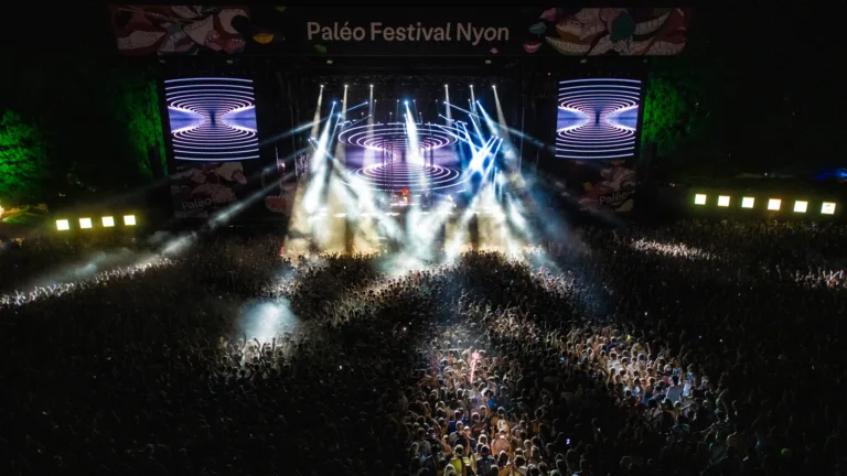 Open-Air-Konzert mit Lichtshow und großer Menschenmenge bei Nacht.