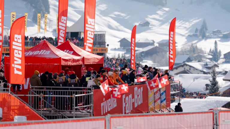Rivella Fan-Bar mit Menschen bei winterlichem Sportanlass in den Alpen.